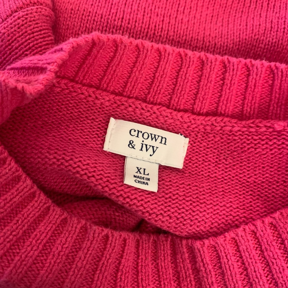Hot pink cardigan with dot pattern and wide sleeve that tapers at wrist.